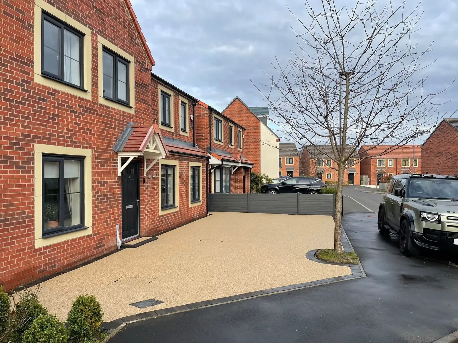 Completed cream resin bound driveway outside a modern red brick home in Newcastle